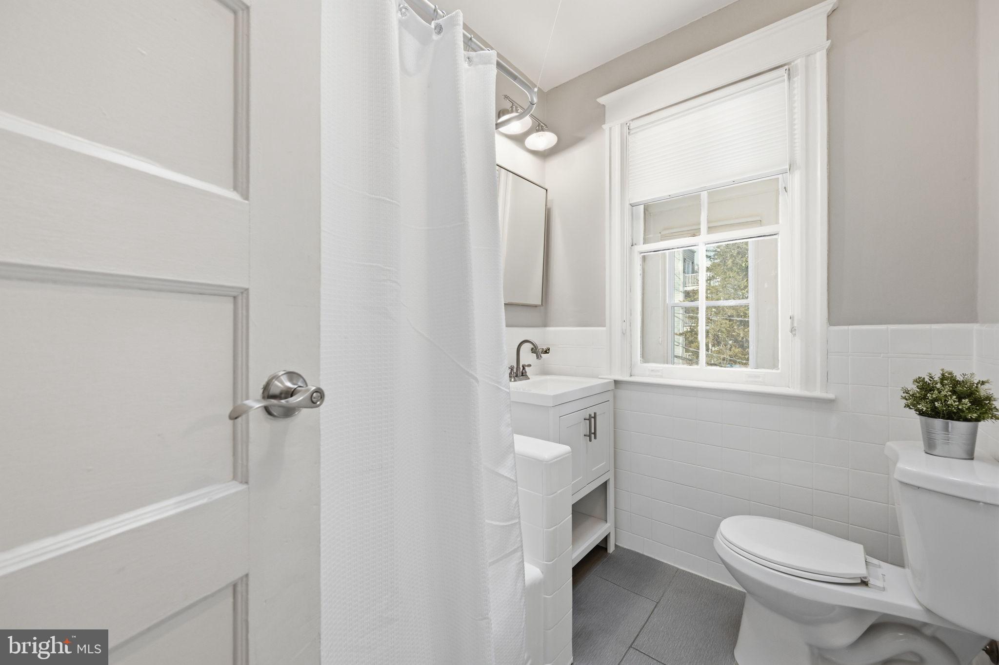 443 Kenyon Street Northwest Washington, DC 20010 - Photo 18 of 30 a bathroom with a sink toilet and shower