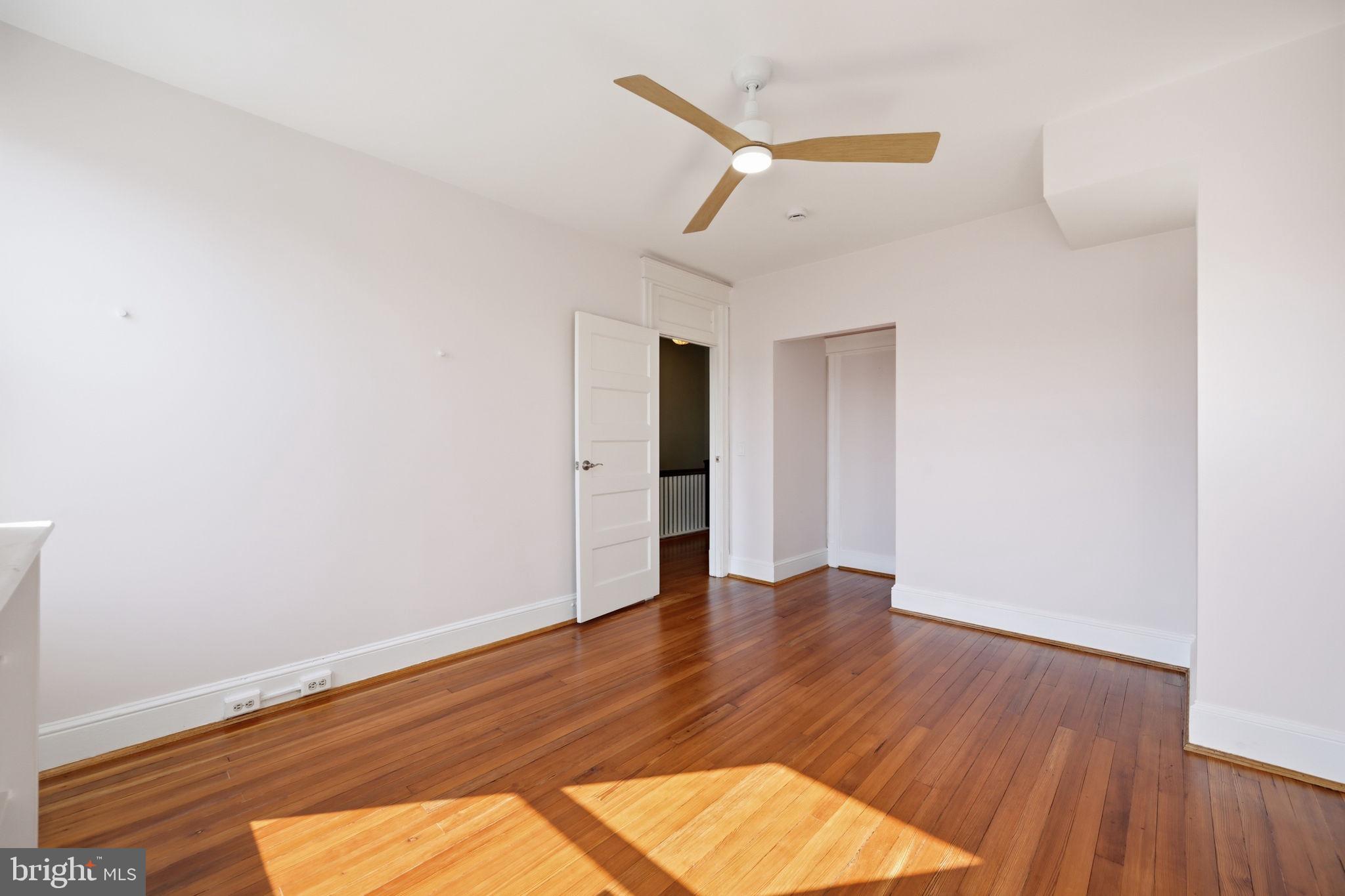 443 Kenyon Street Northwest Washington, DC 20010 - Photo 20 of 30 a view of an empty room with wooden floor and a window