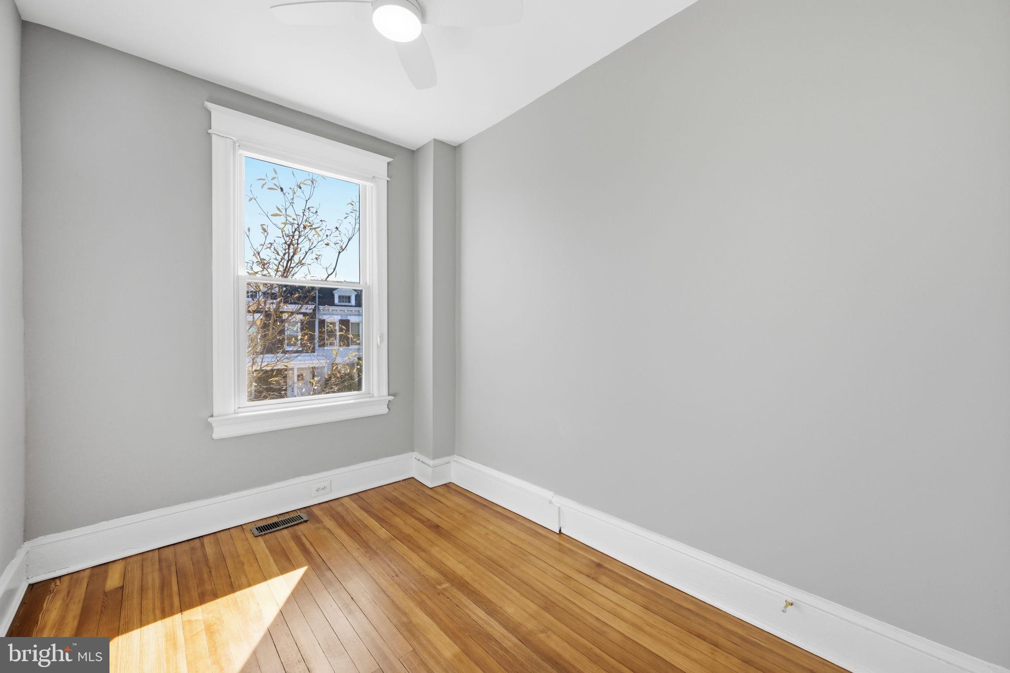 443 Kenyon Street Northwest Washington, DC 20010 - Photo 21 of 30 a view of an empty room with wooden floor and a window