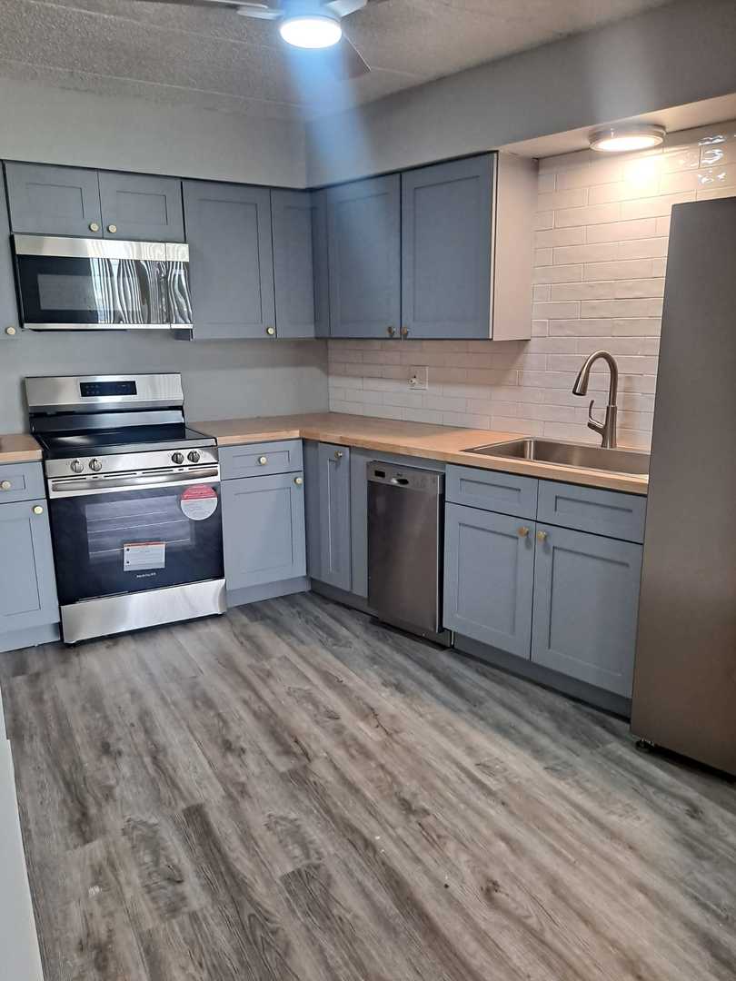 2304 Holiday Terrace, Unit 303 Lansing, IL 60438 - Photo 3 of 11 a kitchen with stainless steel appliances granite countertop a sink and stove top oven