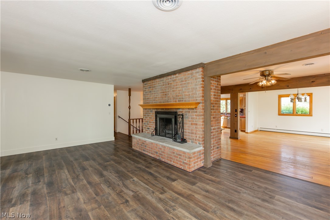 7969 Dines Road Novelty, OH 44072 - Photo 6 of 48 Brick fireplace with a stone hearth and wood mantel separates the kitchen and living room