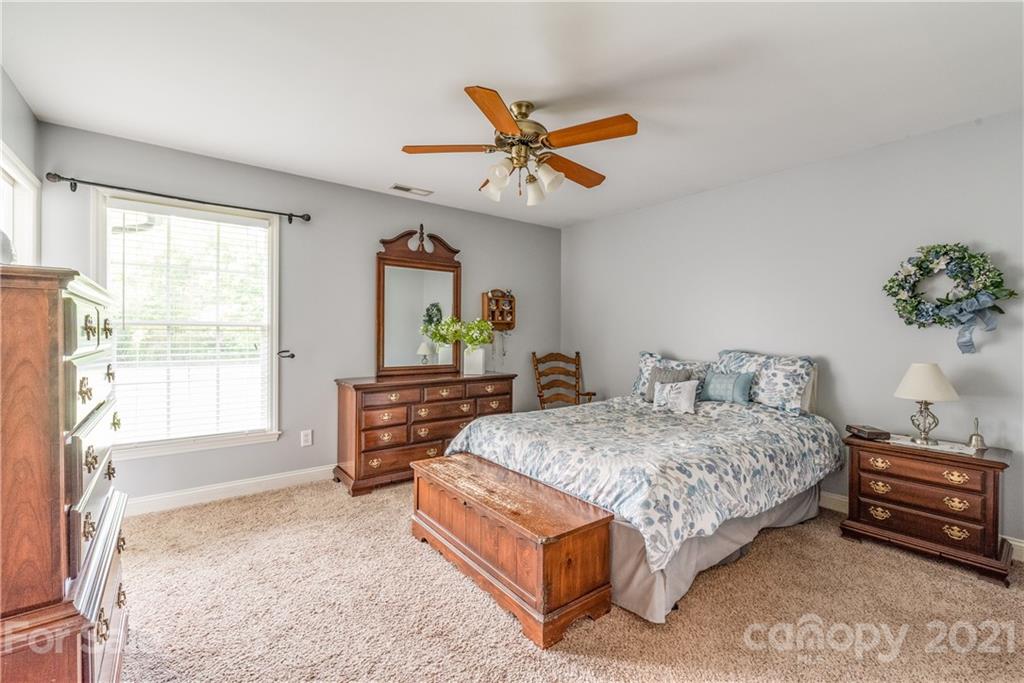 1508 Tom Helms Road Monroe, NC 28110 - Photo 14 of 23 a bedroom with a bed a dresser and a chandelier