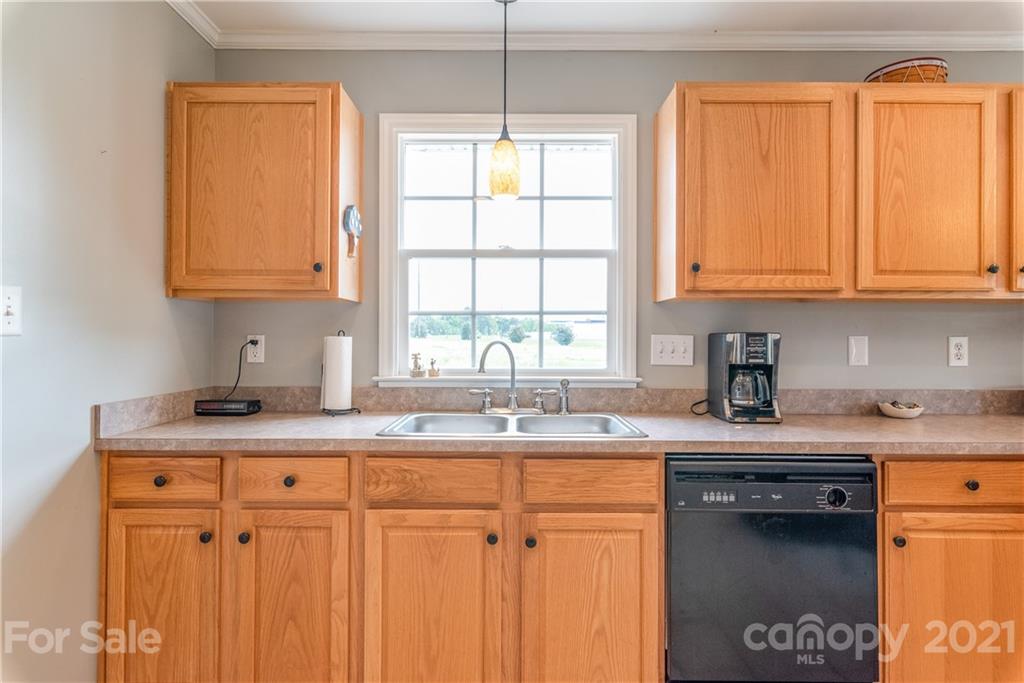 1508 Tom Helms Road Monroe, NC 28110 - Photo 8 of 23 a kitchen with granite countertop a sink a window and cabinets