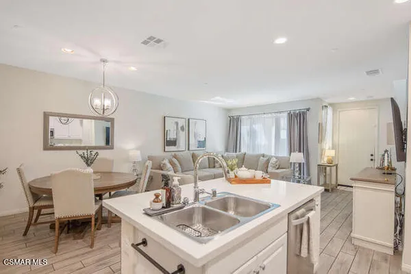 a kitchen with a stove a sink a dining table and chairs