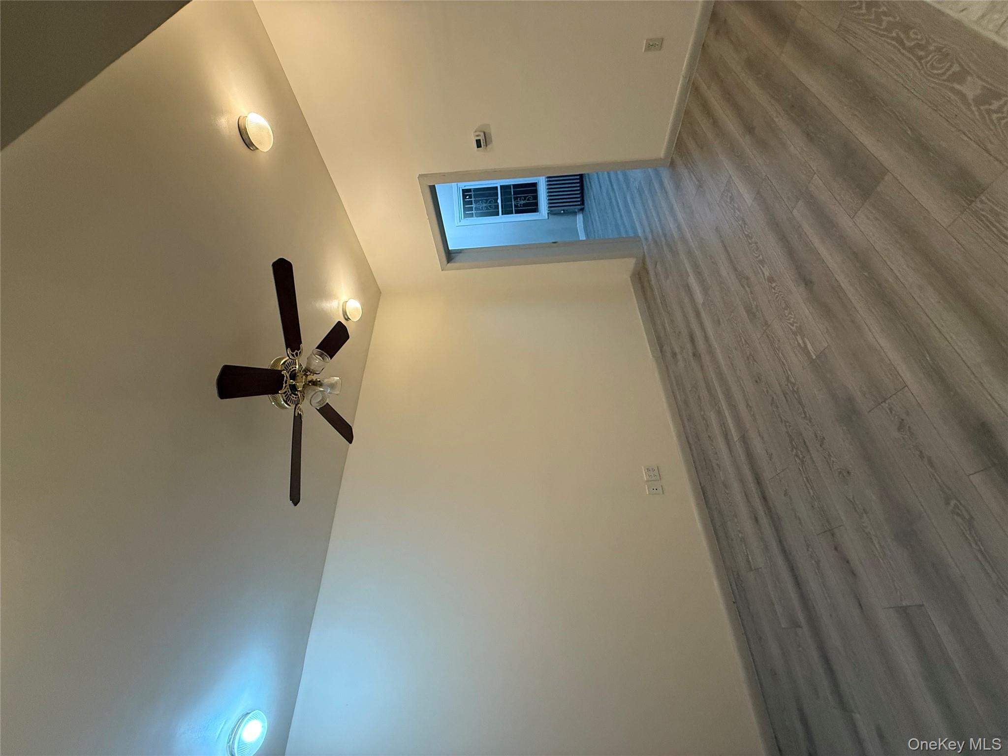 101-58 120th Street Queens, NY 11419 - Photo 3 of 9 a view of empty room with wooden floor and fan