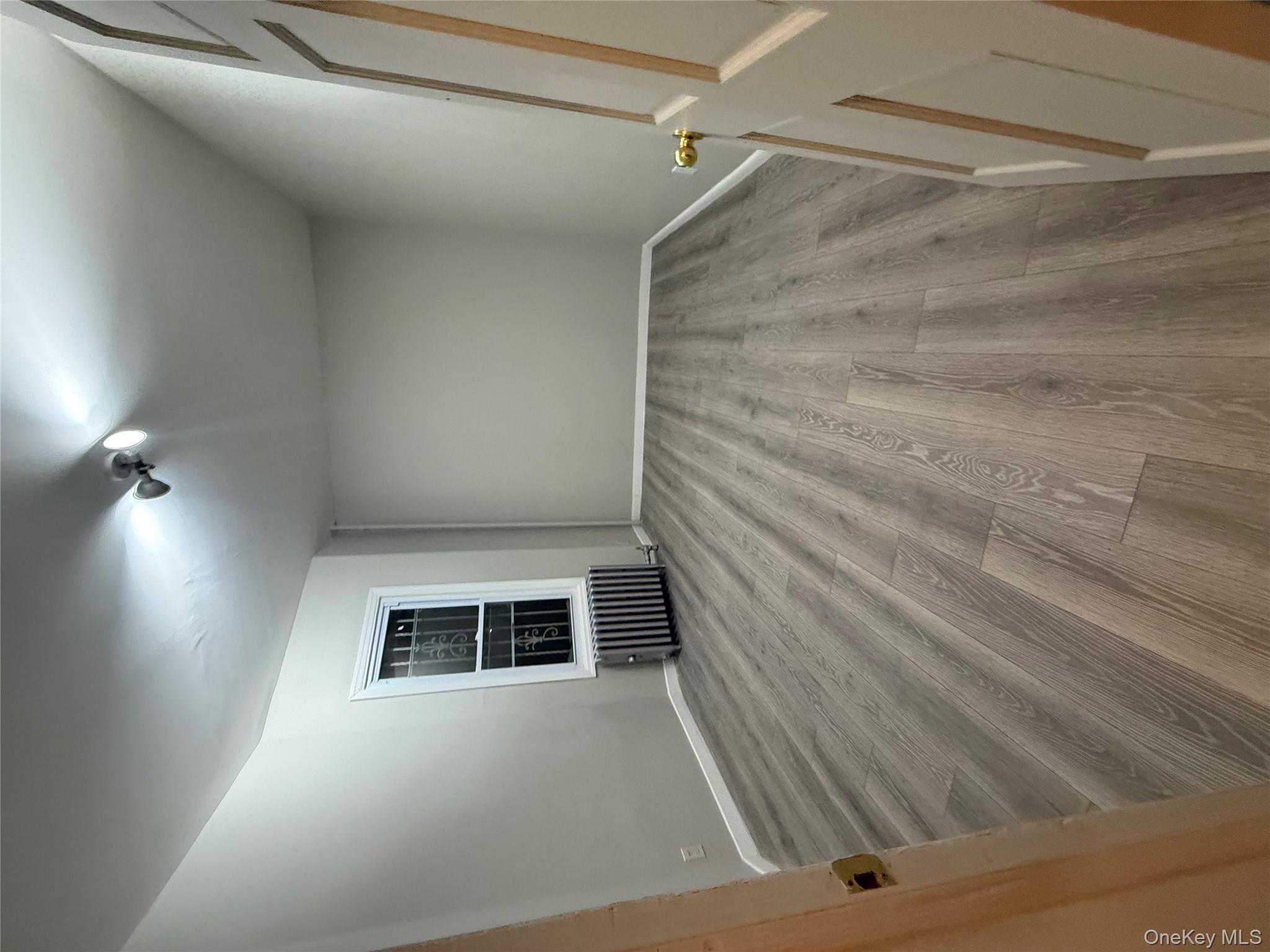 101-58 120th Street Queens, NY 11419 - Photo 8 of 9 an empty room with wooden floor and windows