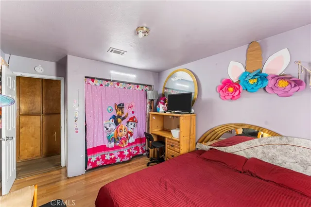 a bedroom with a bed and wooden floor