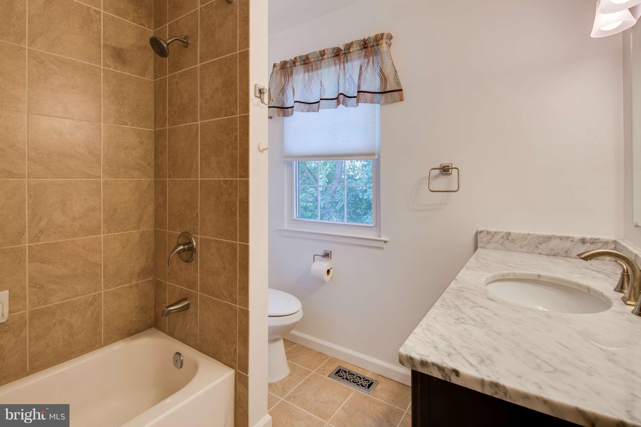 7330 Kindler Road Columbia, MD 21046 - Photo 20 of 28 a bathroom with a granite countertop sink toilet and shower