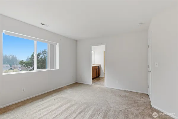 an empty room with a window and a ceiling fan