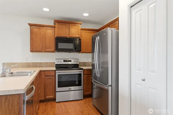 a kitchen with stainless steel appliances granite countertop a refrigerator stove and sink