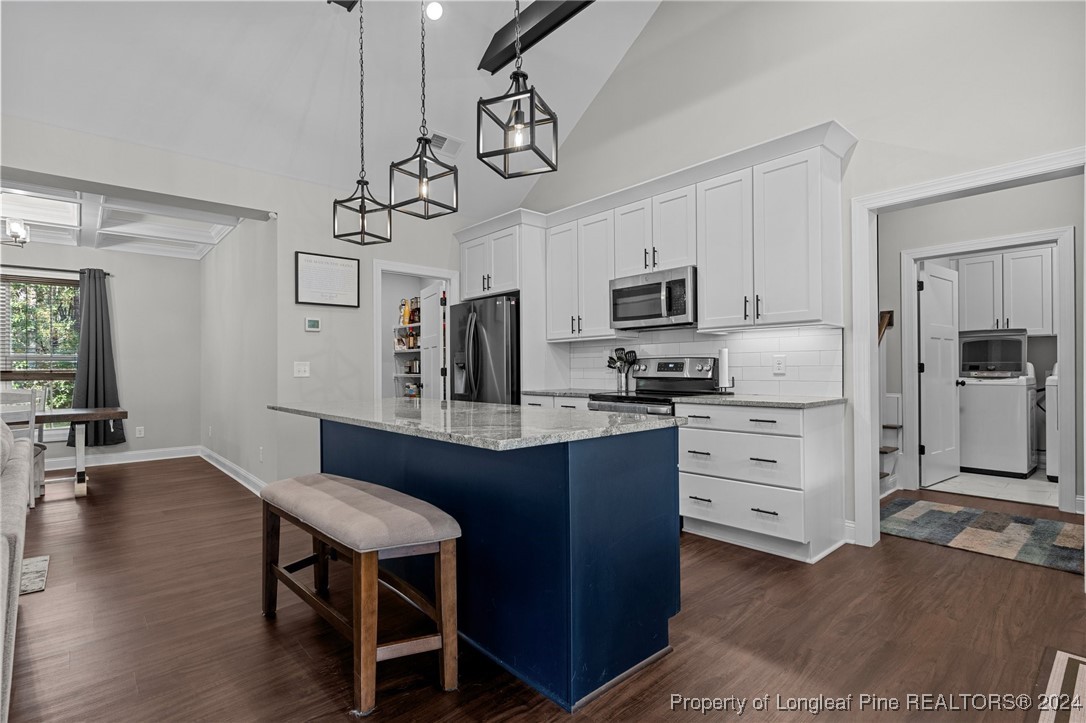 129 Williams Road Southern Pines, NC 28387 - Photo 7 of 26 a kitchen with stainless steel appliances granite countertop a sink a stove a refrigerator cabinets and a dining table with wooden floor