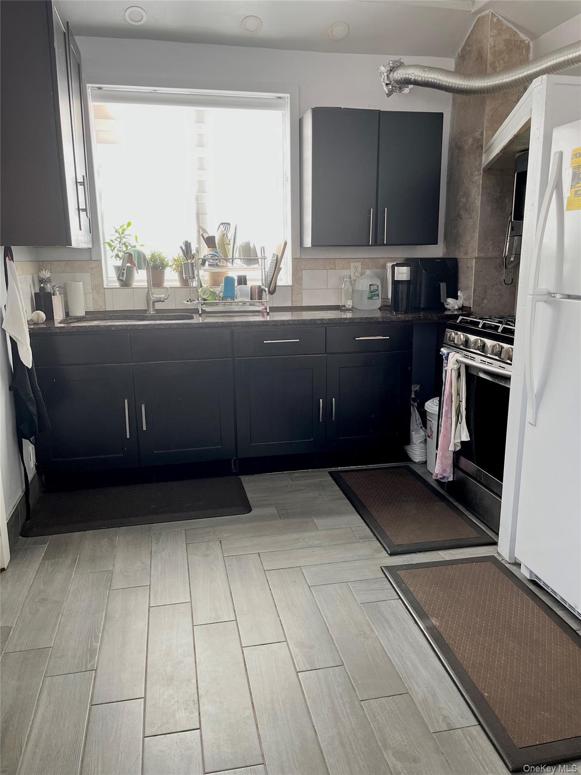 107-33 115th Street Queens, NY 11419 - Photo 4 of 5 a kitchen with a sink a stove and a refrigerator