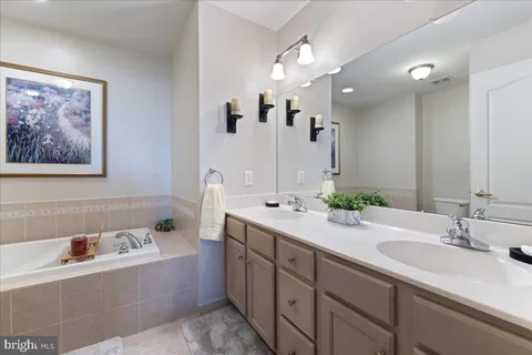 a spacious en suite bathroom with double sink and a mirror