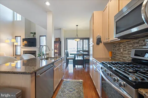 a kitchen with stainless steel appliances granite countertop a sink and a refrigerator