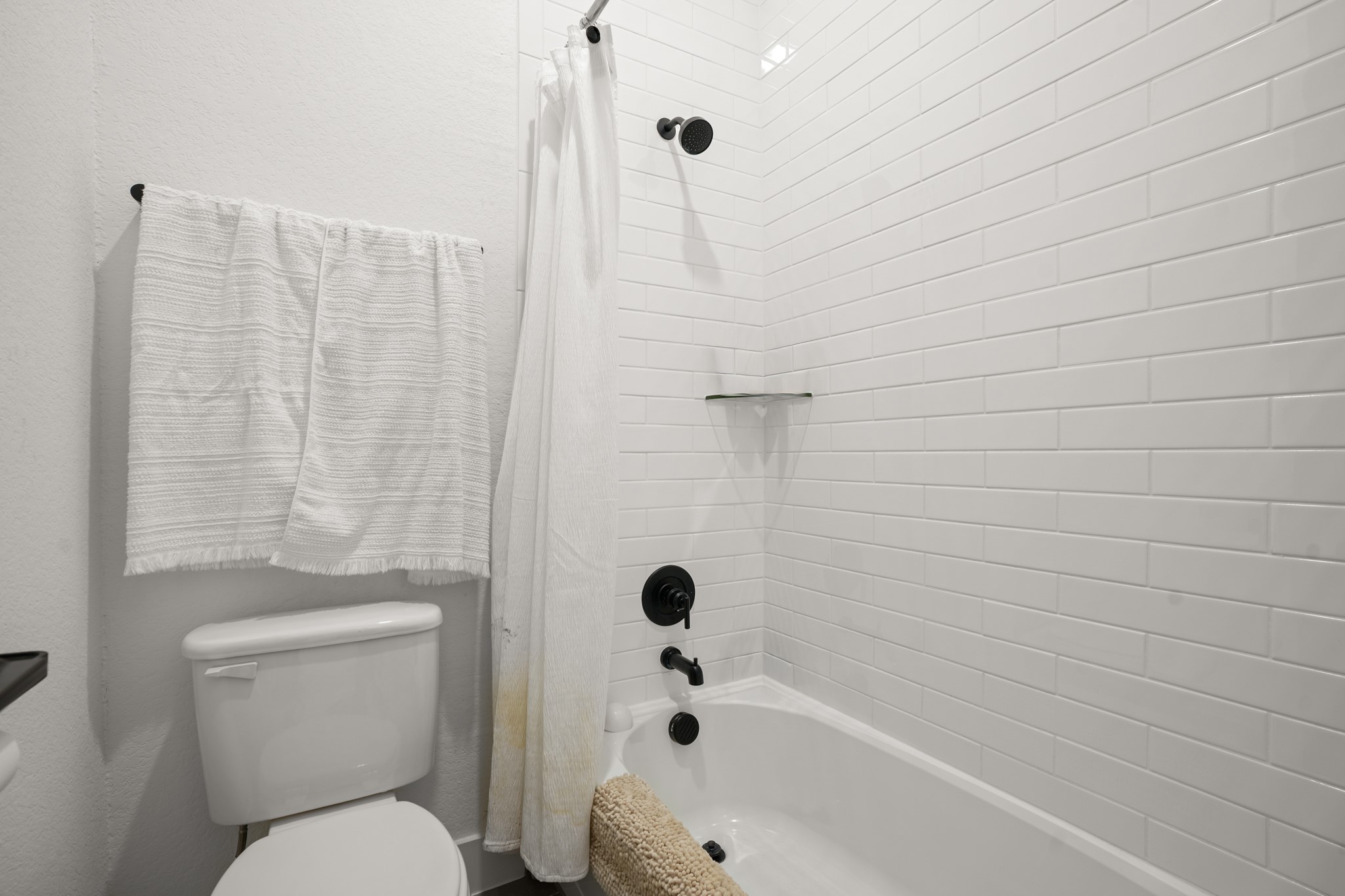 154 LITTLE Strm Cove Austin, TX 78737 - Photo 26 of 37 Crisp subway tile lines the shower surround above a classic tub.