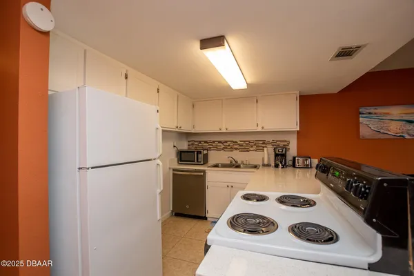 a white refrigerator freezer and a stove sitting inside of a kitchen