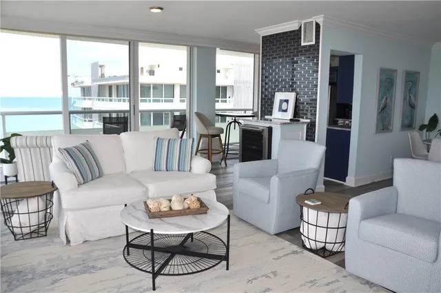 a living room with furniture and a floor to ceiling window
