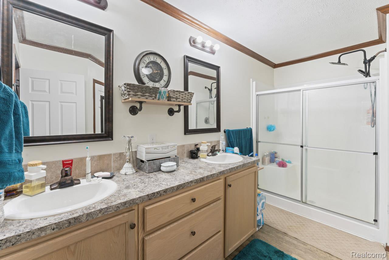 11141 Farrand Road Montrose, MI 48457 - Photo 13 of 51 Full bathroom featuring a shower stall, double vanity, and ornamental molding
