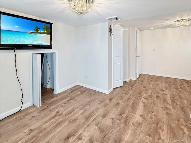 a view of a hallway with wooden floor and a living room