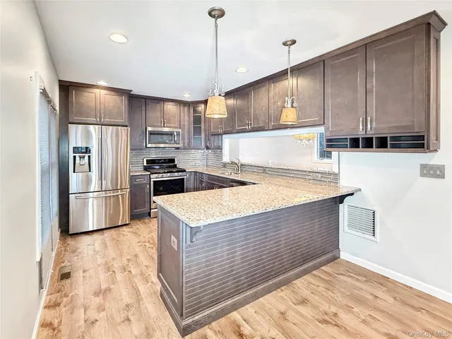 a kitchen with kitchen island a sink stainless steel appliances and counter space