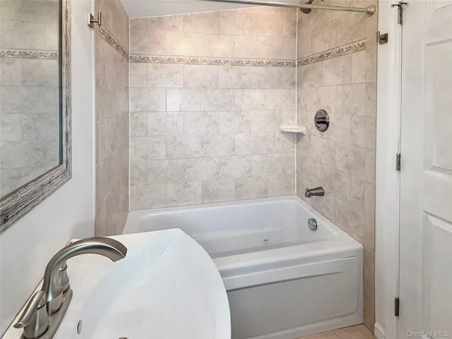 a view of a hallway with wooden floor and chandelier