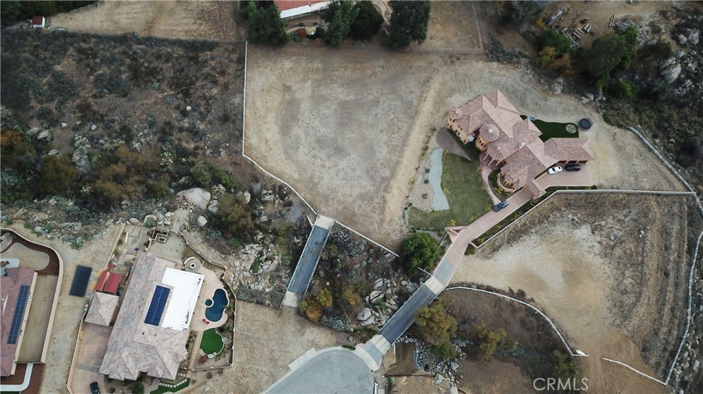 an aerial view of a house with a yard and mountain