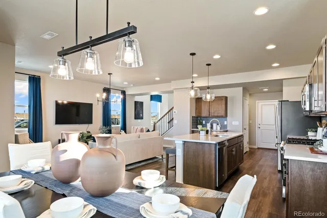 a living room with furniture kitchen view and a wooden floor