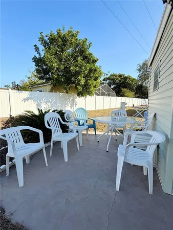 a view of a patio with table and chairs and couches with wooden fence