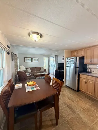 a living room with stainless steel appliances furniture a dining table and chairs