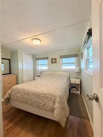 a spacious bedroom with a bed and a dresser with rug