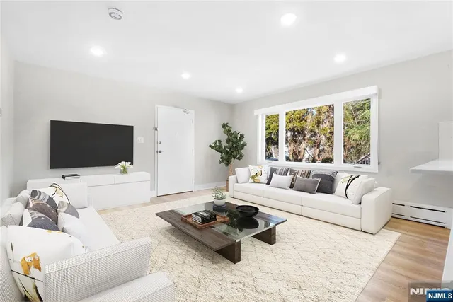 a living room with furniture flat screen tv and a large window