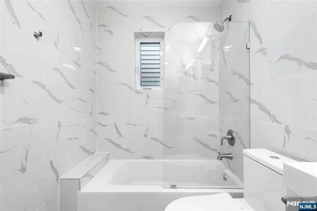 a bathroom with a white bath tub sitting next to a white sink and vanity
