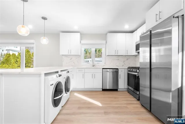 a kitchen with a refrigerator a washer and dryer