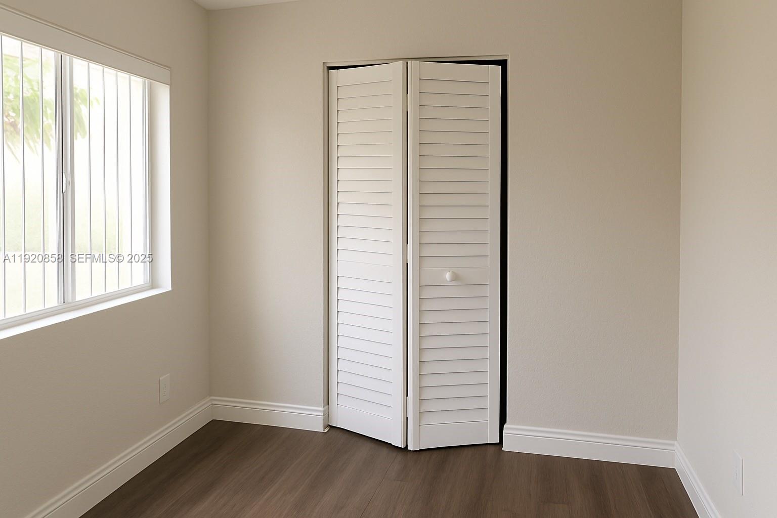4717 Sable Pine Circle, Unit A2 West Palm Beach, FL 33417 - Photo 12 of 15 an empty room with wooden floor and windows