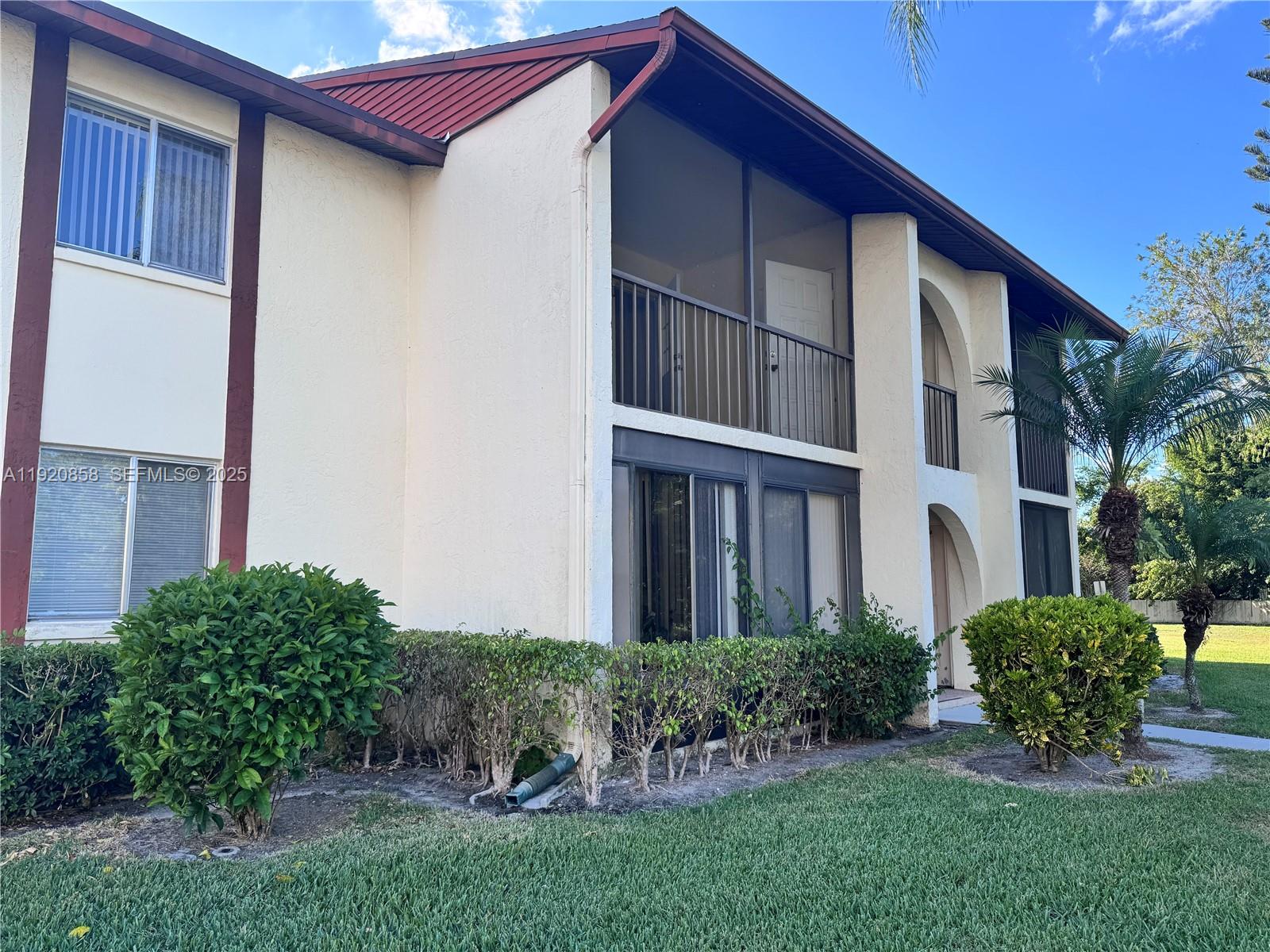 4717 Sable Pine Circle, Unit A2 West Palm Beach, FL 33417 - Photo 13 of 15 a view of a house with brick walls and a yard with plants