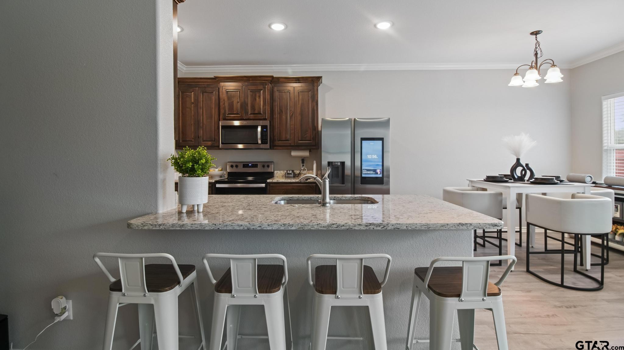 602 North Wofford Street Athens, TX 75751 - Photo 21 of 34 a kitchen with kitchen island granite countertop a table and chairs in it