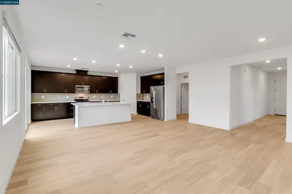 a kitchen with kitchen island granite countertop a sink stainless steel appliances a counter space and cabinets