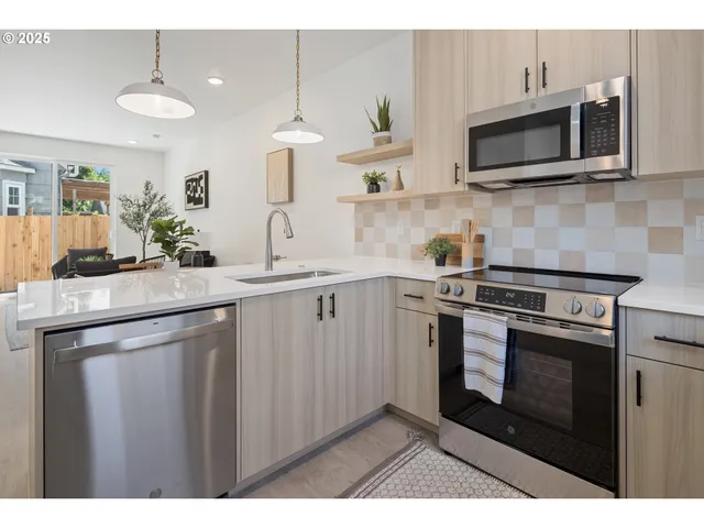a kitchen with kitchen island granite countertop a sink cabinets and stainless steel appliances