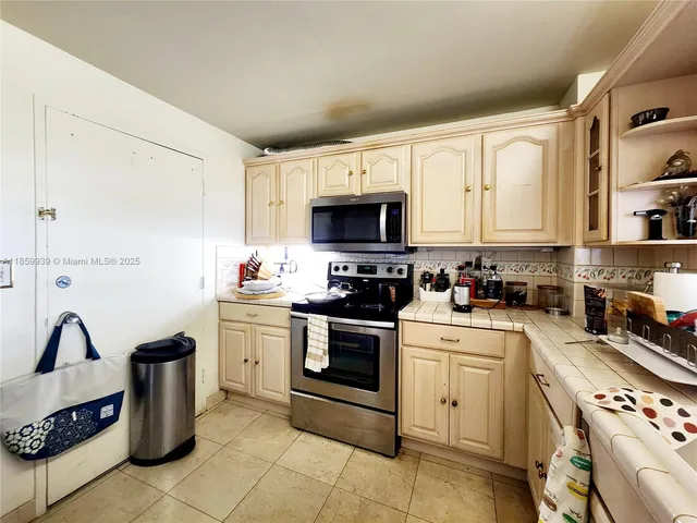 a kitchen with granite countertop a stove a sink and a microwave