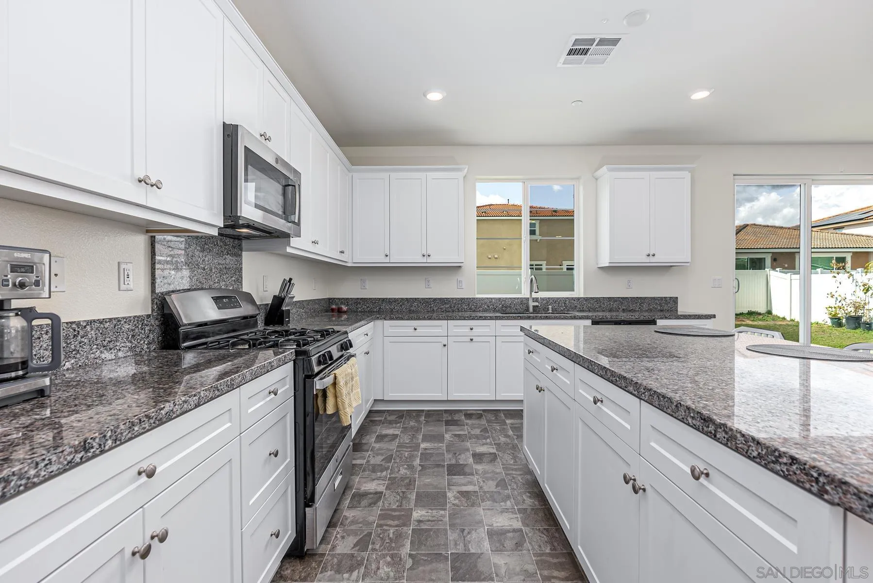 30903 Wild Berry Way Menifee, CA 92584 - Photo 9 of 37 a large kitchen with stainless steel appliances granite countertop a stove sink and cabinets
