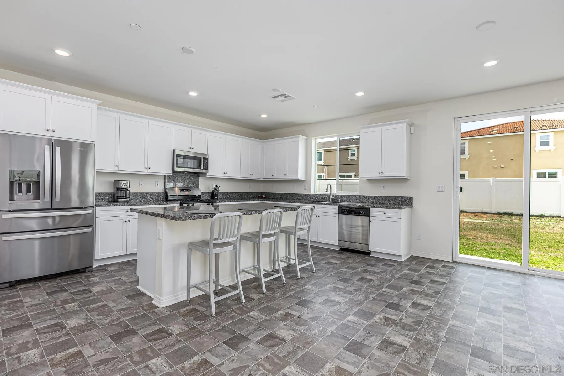 30903 Wild Berry Way Menifee, CA 92584 - Photo 10 of 37 a kitchen with white cabinets and stainless steel appliances