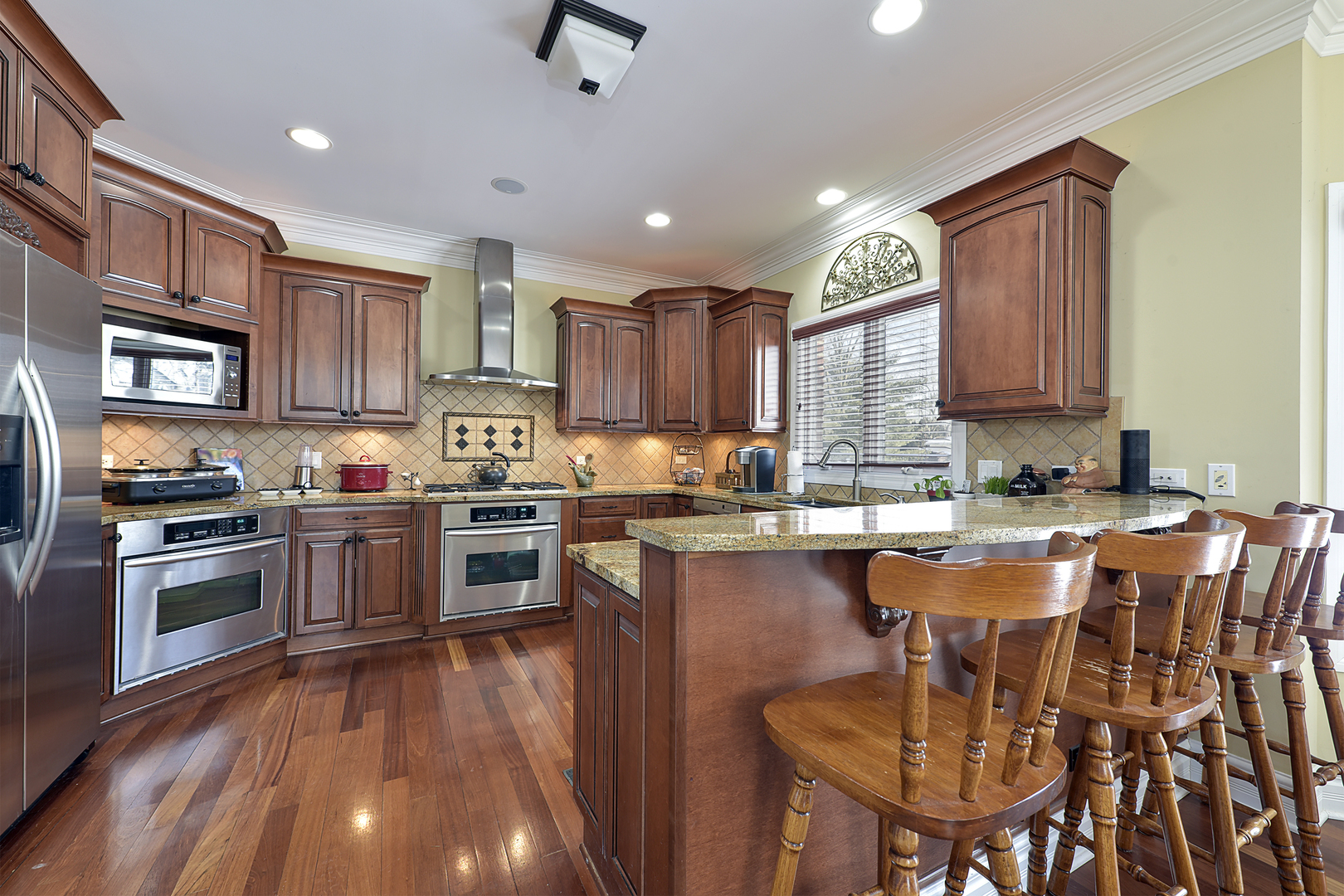 111 Haman Road Inverness, IL 60067 - Photo 6 of 19 a kitchen with stainless steel appliances granite countertop a stove top oven a sink dishwasher a dining table and chairs with wooden floor