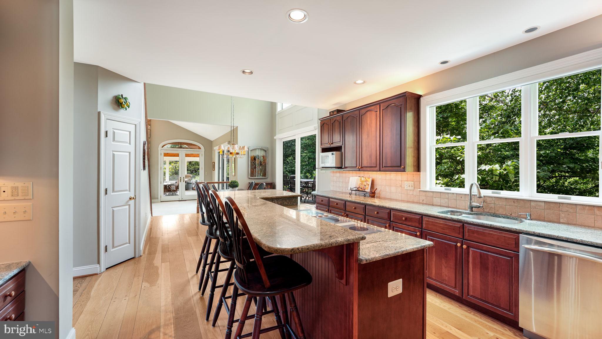 340 West Sandy Ridge Road Doylestown, PA 18901 - Photo 10 of 40 a kitchen with stainless steel appliances granite countertop a table chairs sink and wooden cabinets