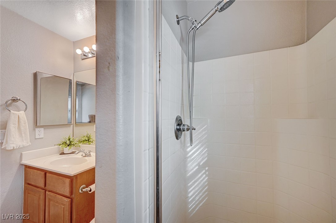 9310 Pinarello Street Las Vegas, NV 89178 - Photo 23 of 61 Full bathroom with a shower stall, vanity, and a textured wall
