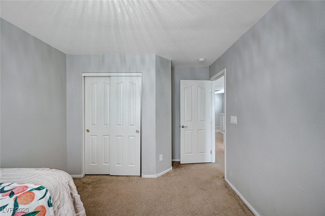 9310 Pinarello Street Las Vegas, NV 89178 - Photo 42 of 61 Bedroom with carpet flooring, a closet, and a textured ceiling