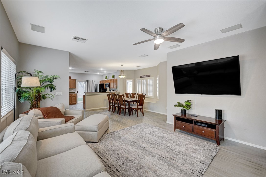 9310 Pinarello Street Las Vegas, NV 89178 - Photo 5 of 61 Living room featuring light wood-style flooring, plenty of natural light, and a ceiling fan