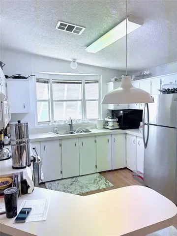 a kitchen with a sink appliances and cabinets