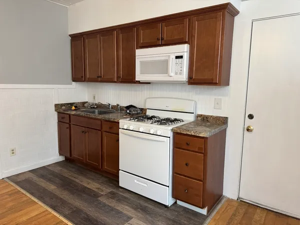 a kitchen with stainless steel appliances granite countertop wooden cabinets sink and a granite counter top