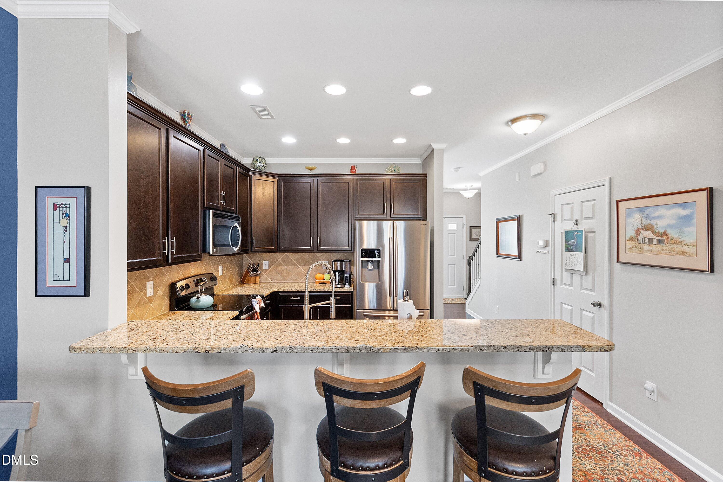 1093 Renewal Place Raleigh, NC 27603 - Photo 11 of 45 a kitchen with granite countertop a dining table chairs cabinets and stainless steel appliances