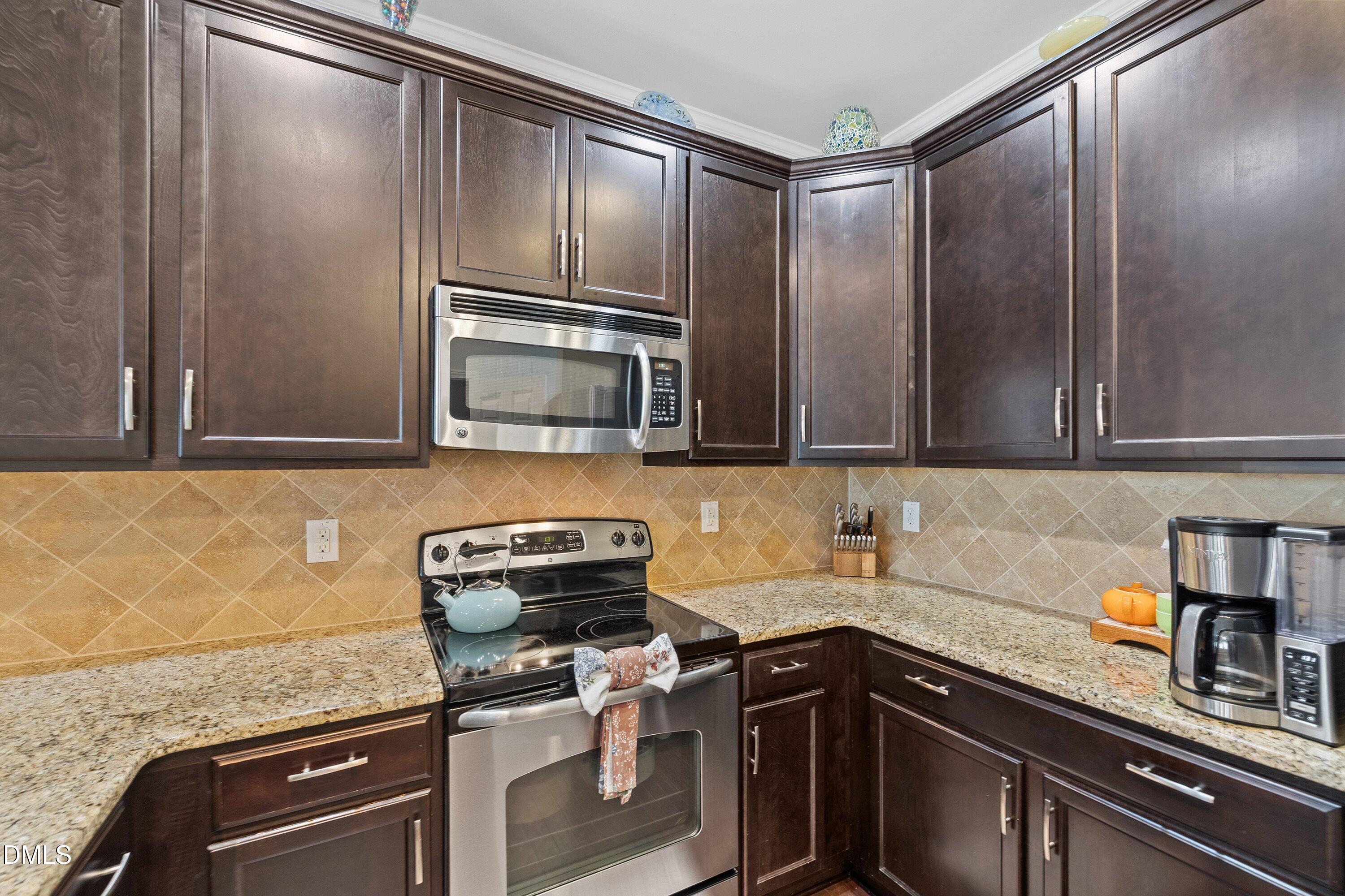 1093 Renewal Place Raleigh, NC 27603 - Photo 13 of 45 a kitchen with stainless steel appliances granite countertop a sink stove and cabinets